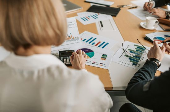 Woman with blonde hair looking at various financial paperwork on a table